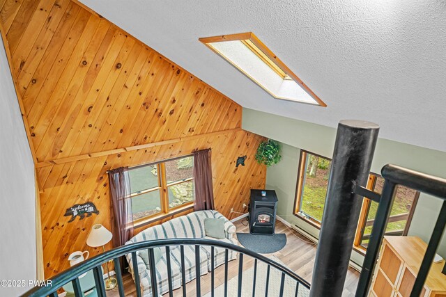 191 Water View Dr, Hawley, PA 18428 - stairway with a skylight, a wood stove, wood walls, lofted ceiling, and wood finished floors