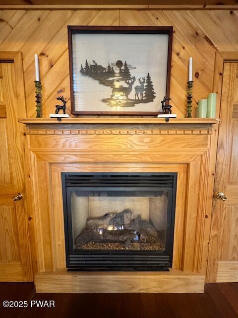 detailed view of a glass covered fireplace and wood walls