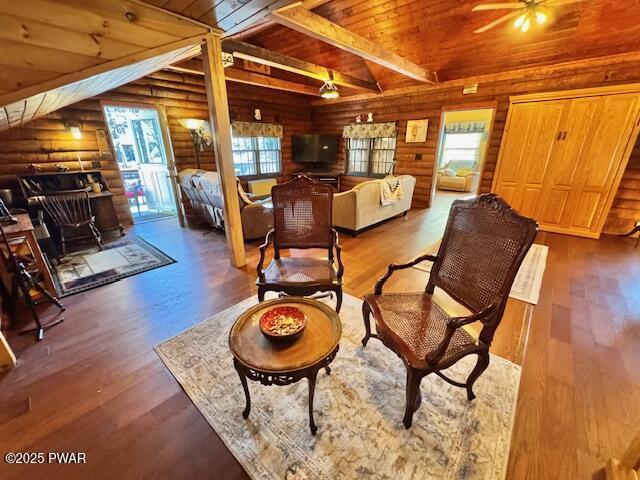 living room featuring wood ceiling, rustic walls, wood finished floors, and a ceiling fan