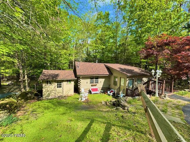 back of property with an outdoor structure and a yard