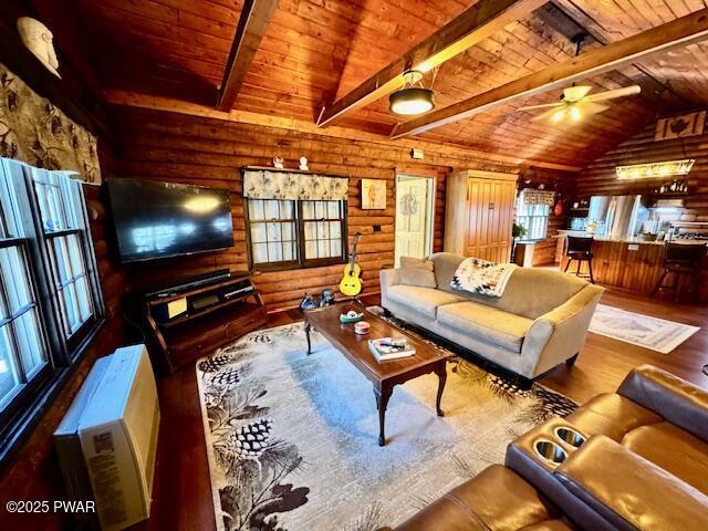 living area featuring wooden ceiling, wood finished floors, rustic walls, and ceiling fan