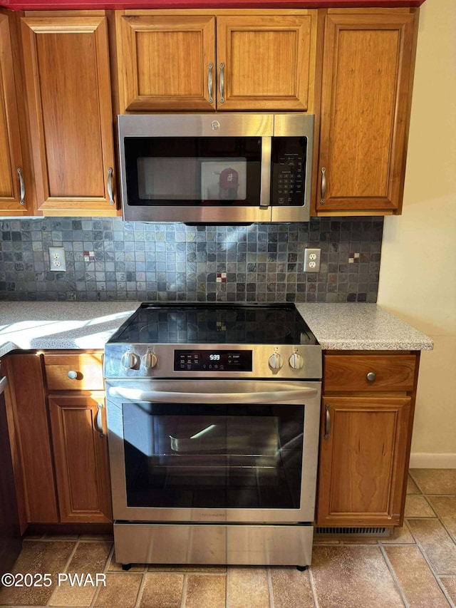 1611 Lake Ariel Hwy, Lake Ariel, PA 18436 - kitchen featuring stainless steel appliances, backsplash, and brown cabinets