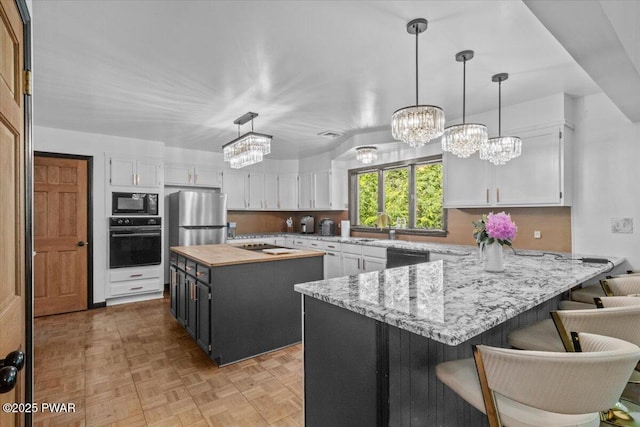 29 Hirshorn Dr, Newfoundland, PA 18445 - kitchen featuring black appliances, a chandelier, white cabinets, a peninsula, and a sink