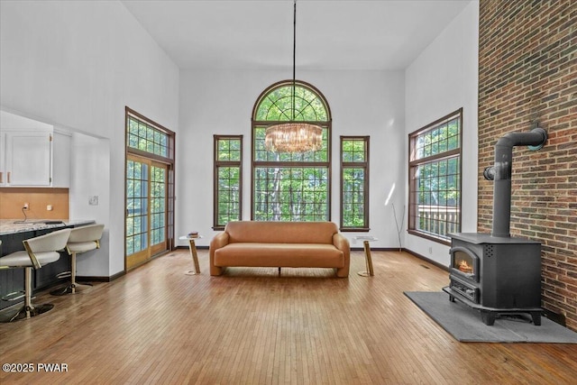 29 Hirshorn Dr, Newfoundland, PA 18445 - living room with light wood-style floors, a wood stove, plenty of natural light, a towering ceiling, and a chandelier