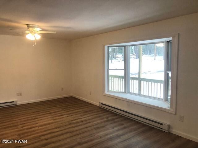 empty room with baseboard heating, dark wood-type flooring, and ceiling fan