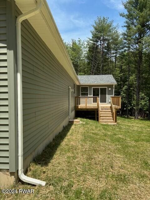 view of property exterior with a yard and a wooden deck