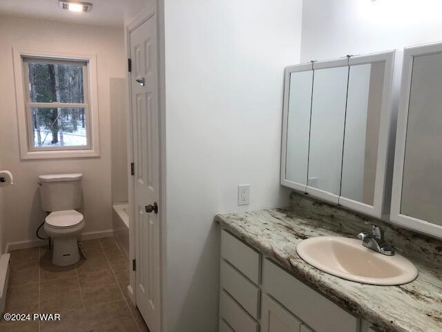 bathroom featuring tile patterned floors, vanity, and toilet