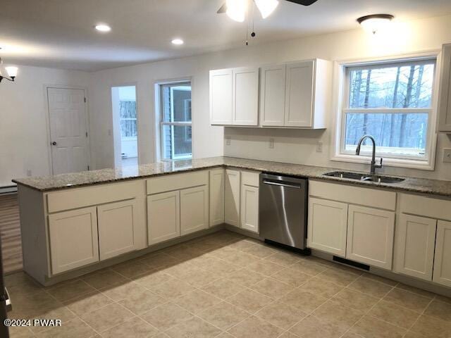 kitchen featuring light stone countertops, sink, stainless steel dishwasher, kitchen peninsula, and ceiling fan with notable chandelier