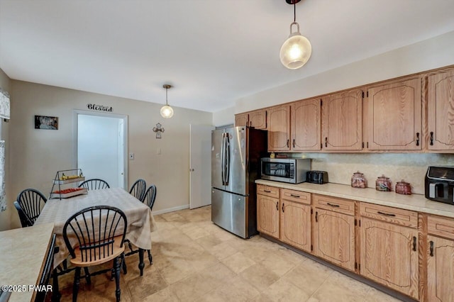 kitchen featuring decorative light fixtures, backsplash, and appliances with stainless steel finishes