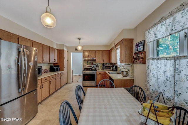 kitchen featuring decorative light fixtures, appliances with stainless steel finishes, and sink