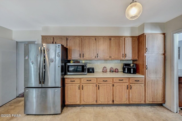 kitchen with stainless steel appliances, pendant lighting, and tasteful backsplash