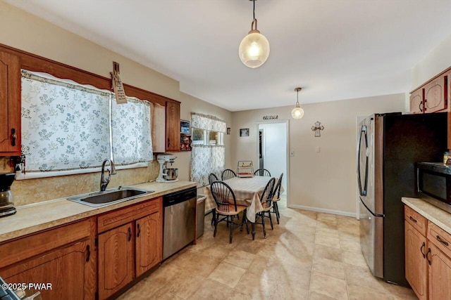 kitchen with pendant lighting, appliances with stainless steel finishes, and sink