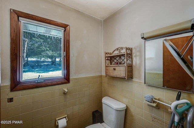 bathroom with toilet and tile walls