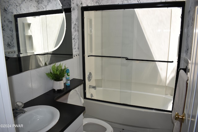 full bathroom featuring vanity, backsplash, toilet, and bath / shower combo with glass door