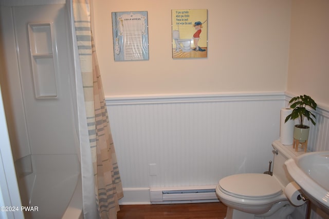 bathroom featuring a shower with curtain, toilet, baseboard heating, and sink