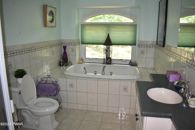 bathroom featuring a washtub, vanity, tile patterned floors, and plenty of natural light