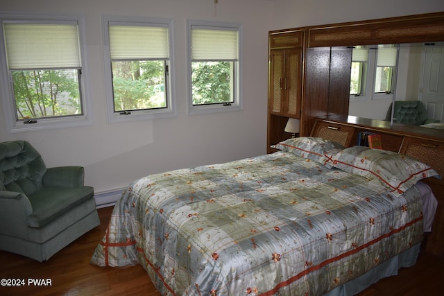 bedroom with a baseboard radiator and wood-type flooring