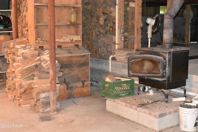 interior space featuring concrete flooring and a wood stove