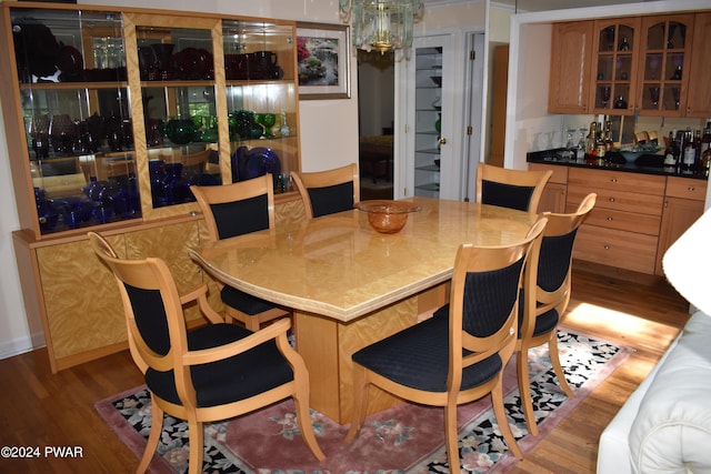 dining room with indoor bar and dark wood-type flooring