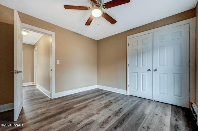 unfurnished bedroom with ceiling fan, wood-type flooring, and a closet