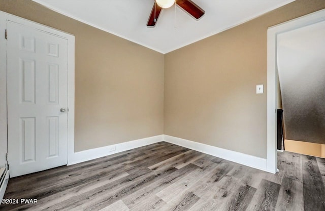 unfurnished room featuring hardwood / wood-style flooring, ceiling fan, and baseboard heating