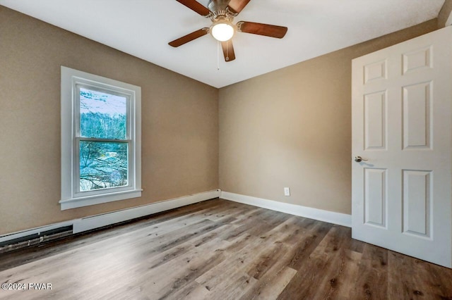 empty room with hardwood / wood-style floors, ceiling fan, and a baseboard radiator