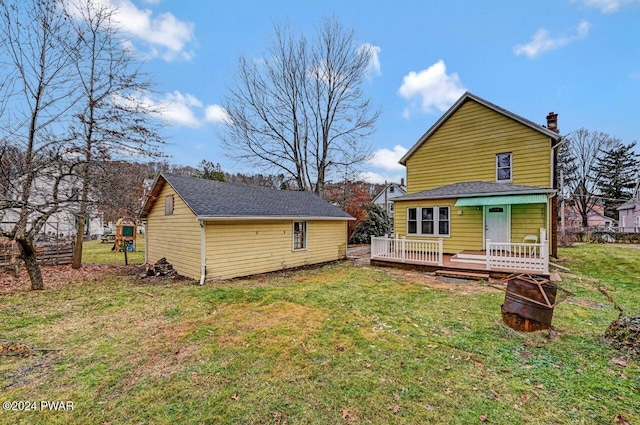 rear view of house with a yard and a wooden deck