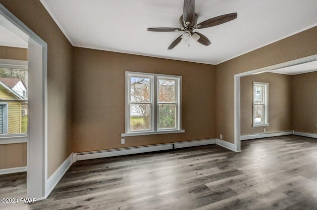 empty room featuring dark hardwood / wood-style floors, ceiling fan, and a baseboard heating unit