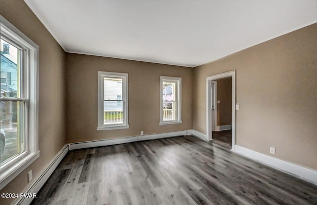 spare room with plenty of natural light, a baseboard radiator, and hardwood / wood-style flooring