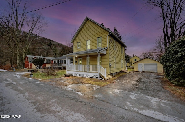 view of front facade with an outbuilding, a porch, and a garage