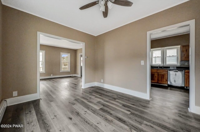 unfurnished room featuring hardwood / wood-style floors, ceiling fan, a healthy amount of sunlight, and a baseboard heating unit