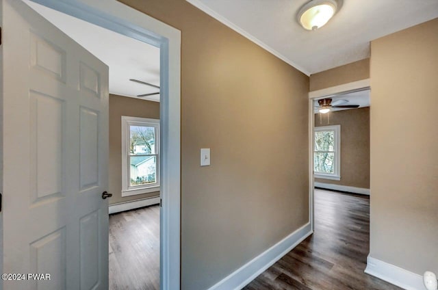 corridor with dark hardwood / wood-style flooring and baseboard heating