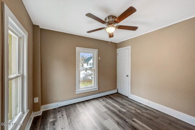 spare room featuring hardwood / wood-style floors, a baseboard radiator, and ceiling fan