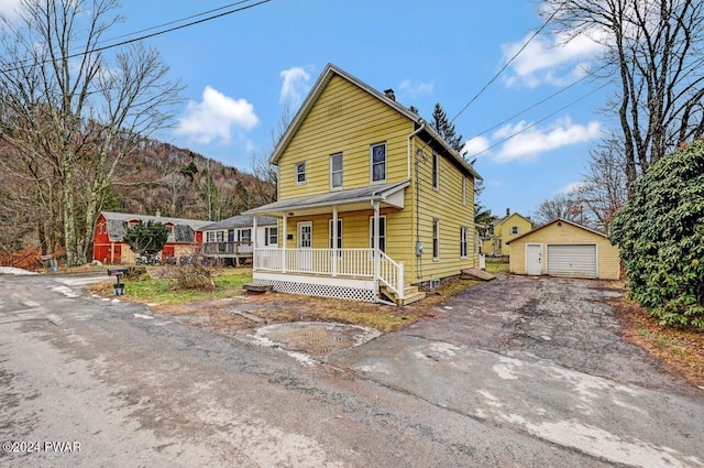 view of front facade featuring a mountain view, a porch, an outdoor structure, and a garage