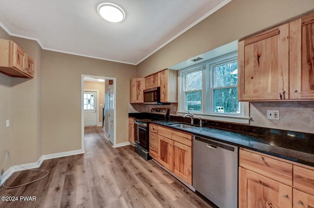 kitchen with light brown cabinets, sink, light wood-type flooring, and stainless steel appliances