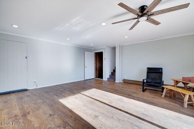 unfurnished living room featuring hardwood / wood-style flooring, ceiling fan, and ornamental molding