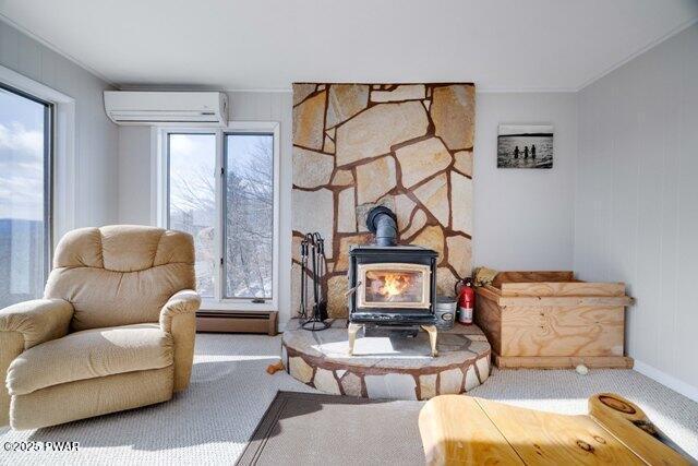 living area with baseboard heating, a wood stove, carpet floors, and a wall unit AC