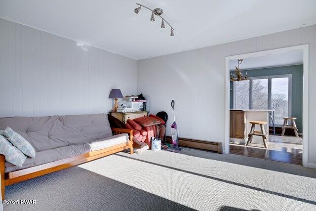 carpeted living room with track lighting and a notable chandelier