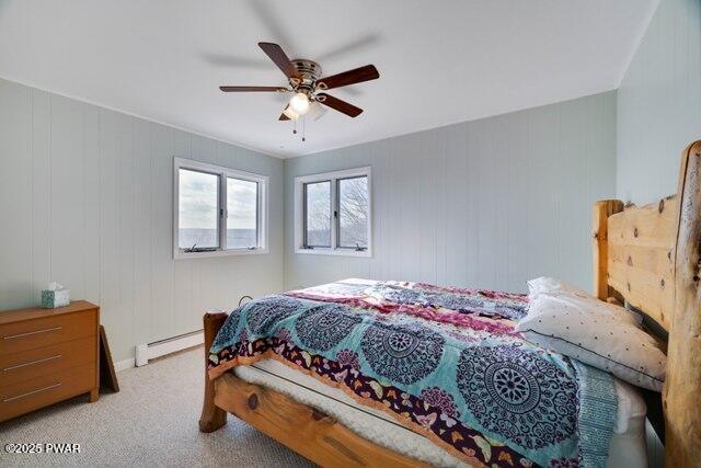 bedroom with ceiling fan, baseboard heating, and light carpet