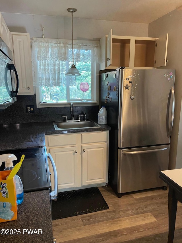 110 Gold Key Rd, Milford, PA 18337 - kitchen with freestanding refrigerator, dark countertops, wood finished floors, and white cabinetry