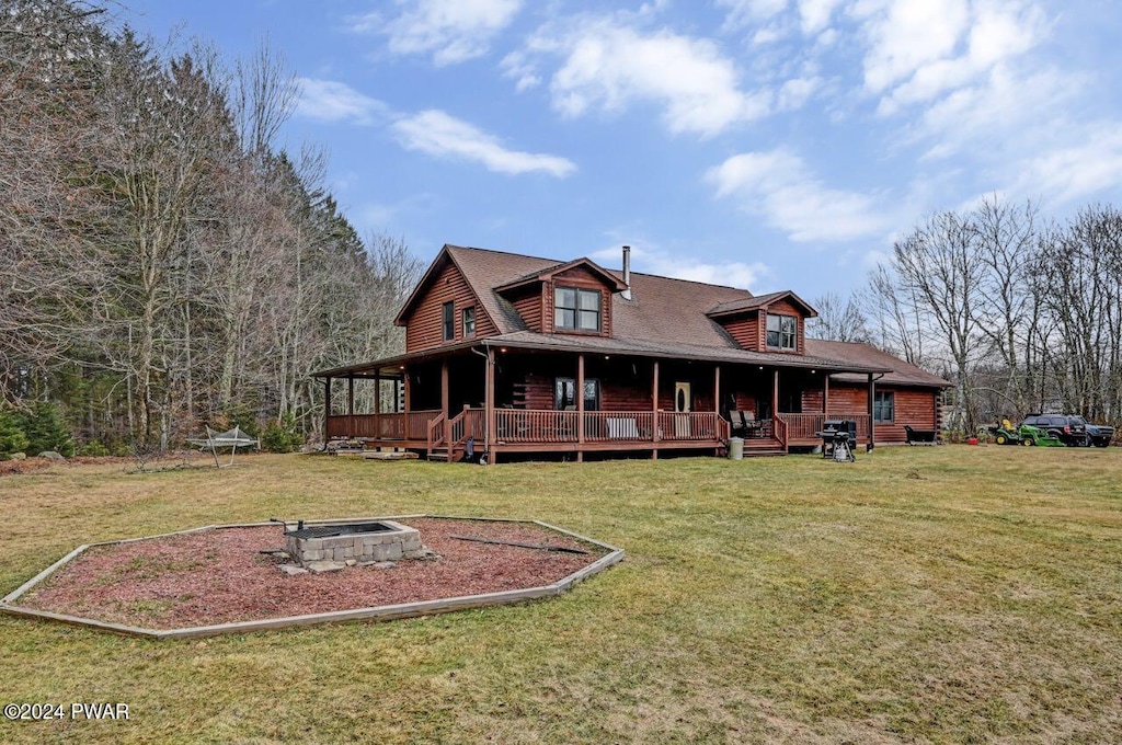 rear view of house featuring a lawn and an outdoor fire pit