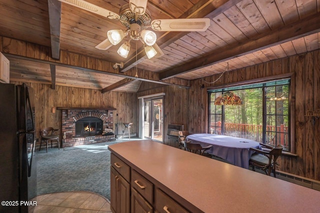 77 Brookfield Rd, Lake Ariel, PA 18436 - kitchen featuring freestanding refrigerator, a wood ceiling with exposed beams, wood walls, a ceiling fan, and a fireplace