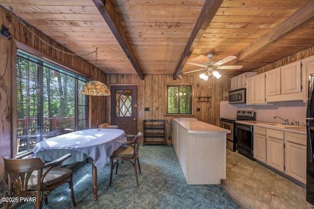 77 Brookfield Rd, Lake Ariel, PA 18436 - kitchen featuring stainless steel appliances, a wooden ceiling with exposed beams, light countertops, wood walls, and ceiling fan