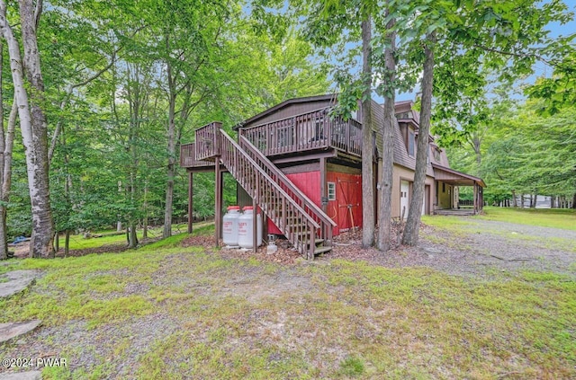 rear view of house with a deck and a garage