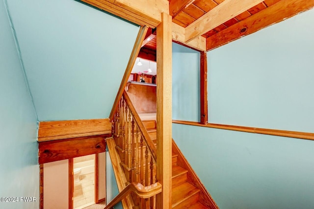 stairs featuring beam ceiling and wood ceiling