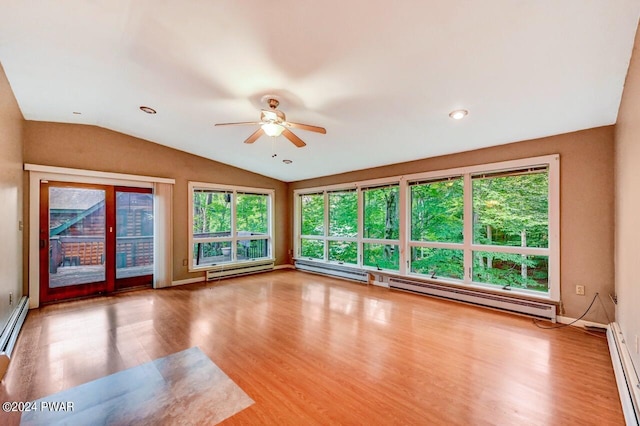 unfurnished room featuring baseboard heating, vaulted ceiling, ceiling fan, and a healthy amount of sunlight