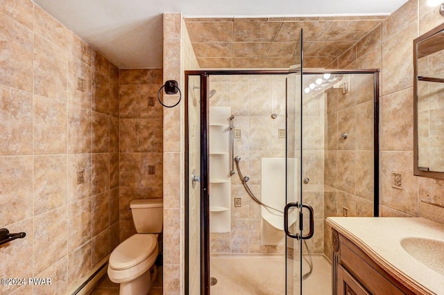 bathroom with walk in shower, vanity, tile walls, and toilet