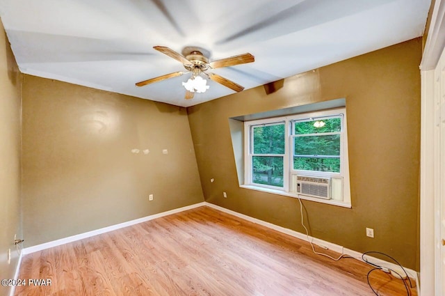 spare room with light wood-type flooring, cooling unit, and ceiling fan