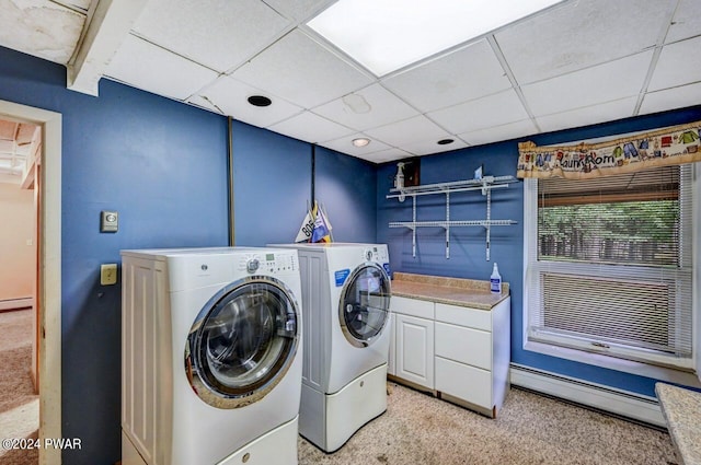 washroom featuring light carpet, washing machine and dryer, baseboard heating, and cabinets