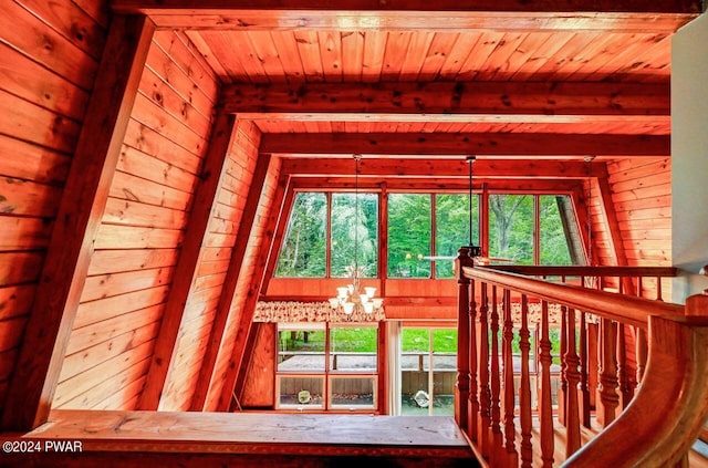 interior space featuring beam ceiling, wooden ceiling, and a notable chandelier